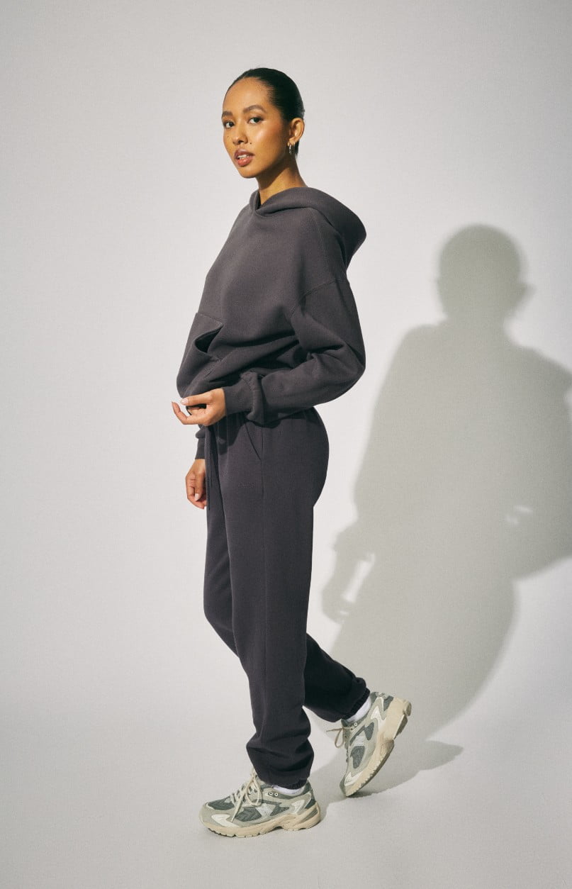 Model wears a dark grey hoodie and matching sweatpants.
