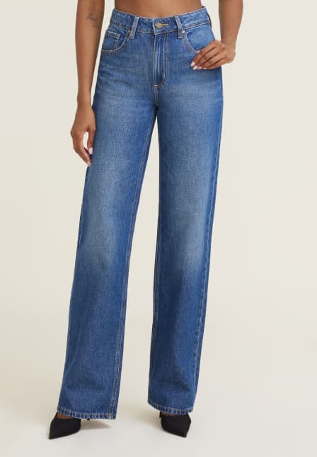 Model is wearing medium blue wide leg jeans.