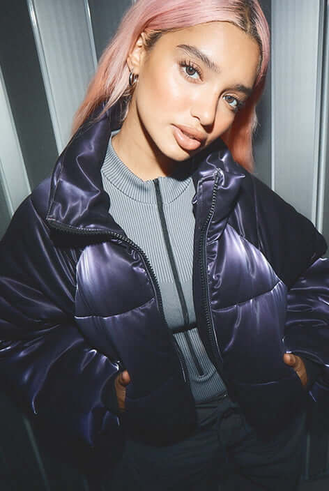 Model is wearing a shiny purple puffer jackets.