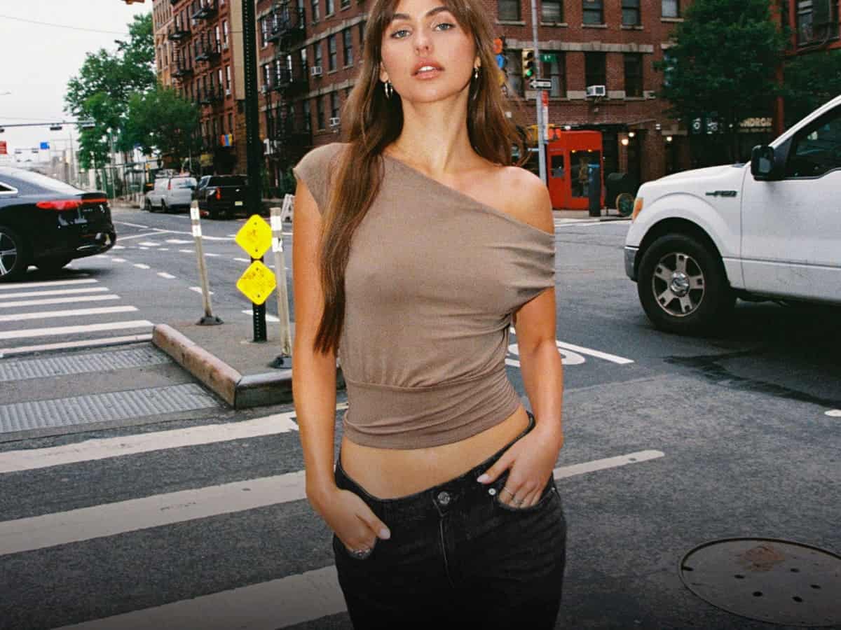Model poses in a taupe off the shoulder top.