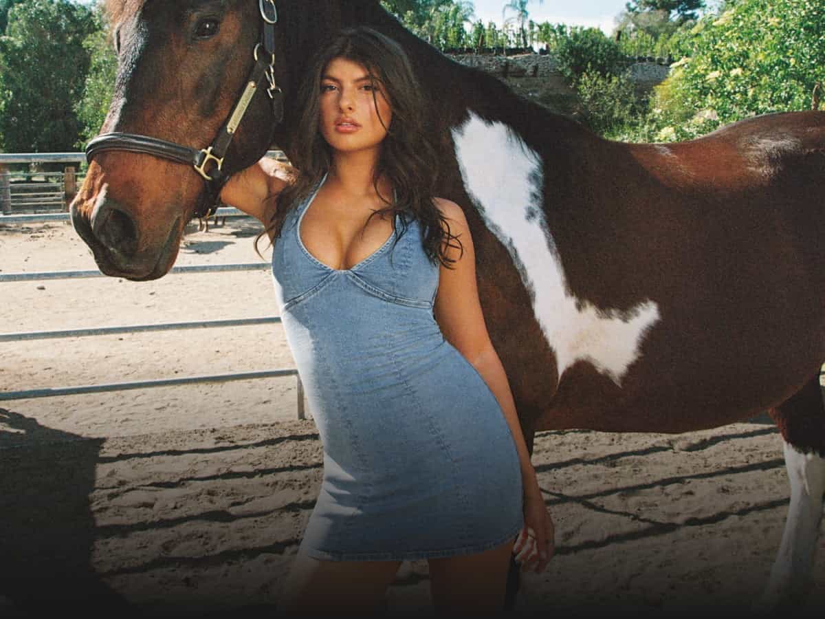 Model poses in a denim mini dress.