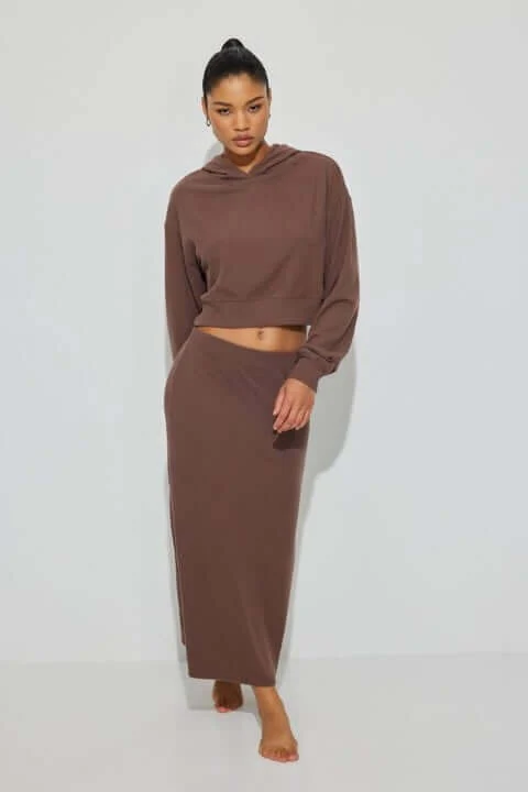 Model wears a brown sweatshirt with a matching skirt.