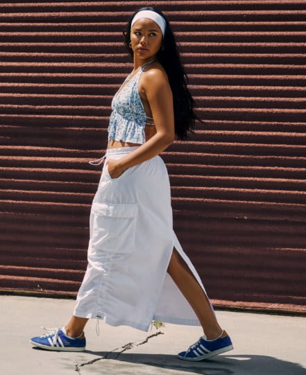 Model is wearing a white cargo skirt and matching top.