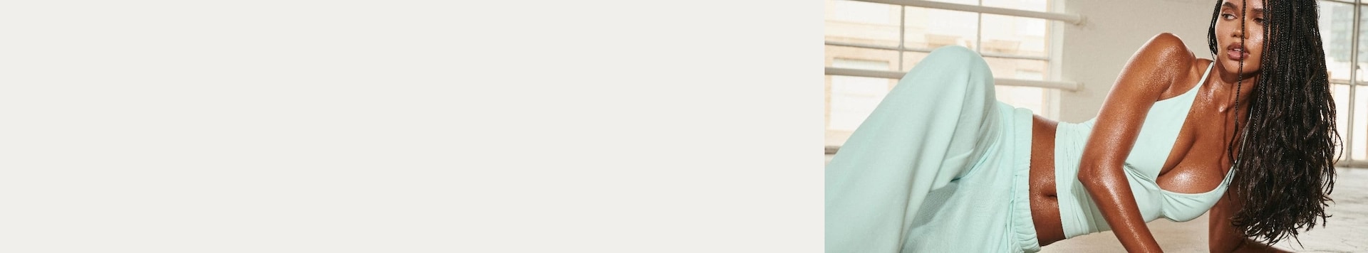 Model poses in a mint tank top and matching sweats.