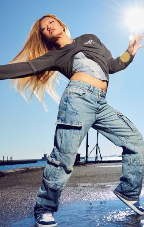 Model is wearing denim, a top, and a fleece jacket.