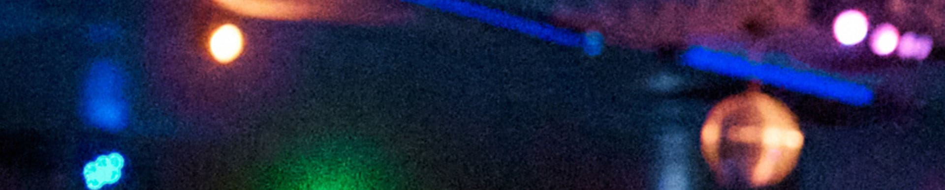 Blurred out background with different colored lights: blue, orange, green, and purple.