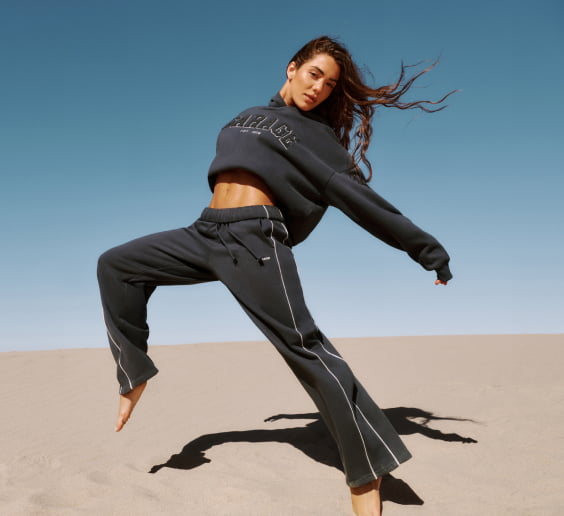 La mannequin prend la pose dans un chandail GARAGE gris foncé et un pantalon de jogging assorti.