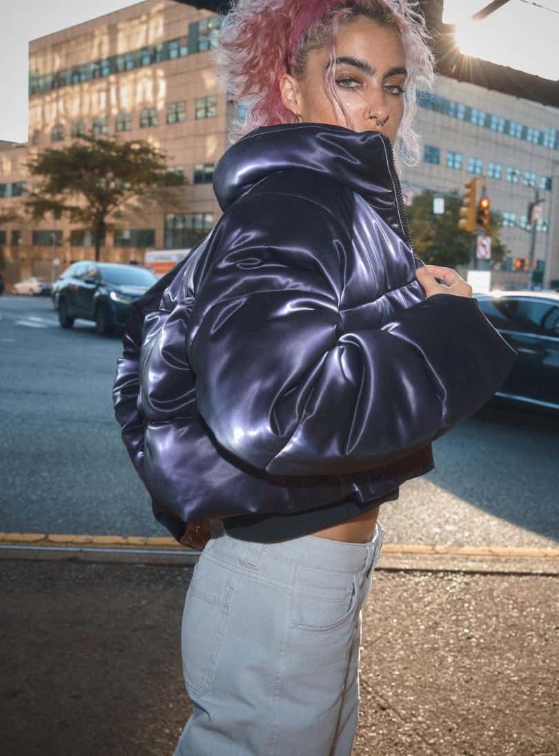 Model is wearing cropped purple puffer.