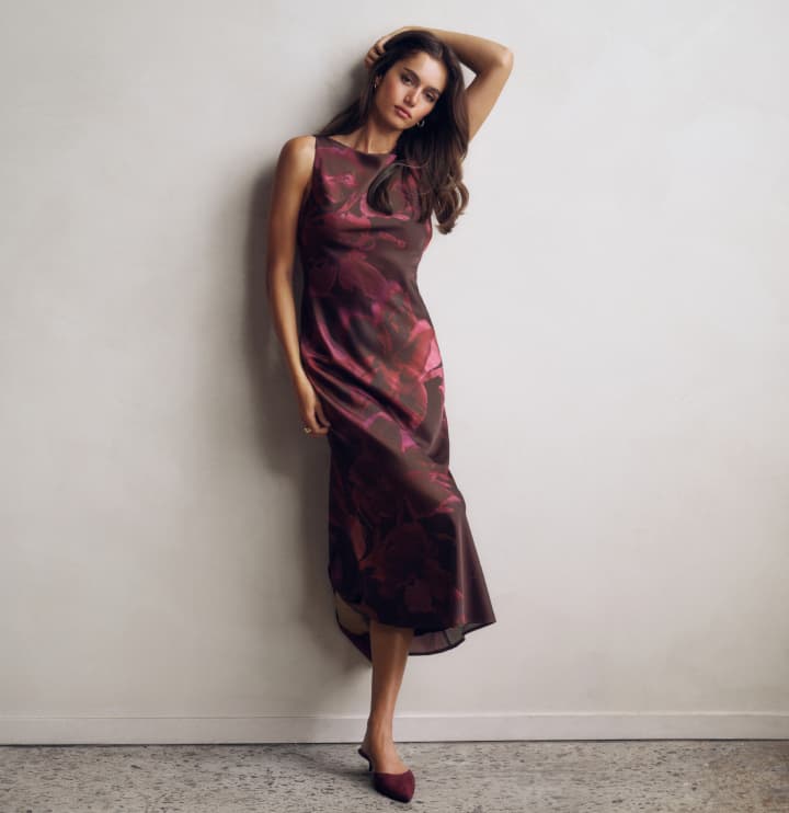 Model is wearing a burgundy floral maxi dress.
