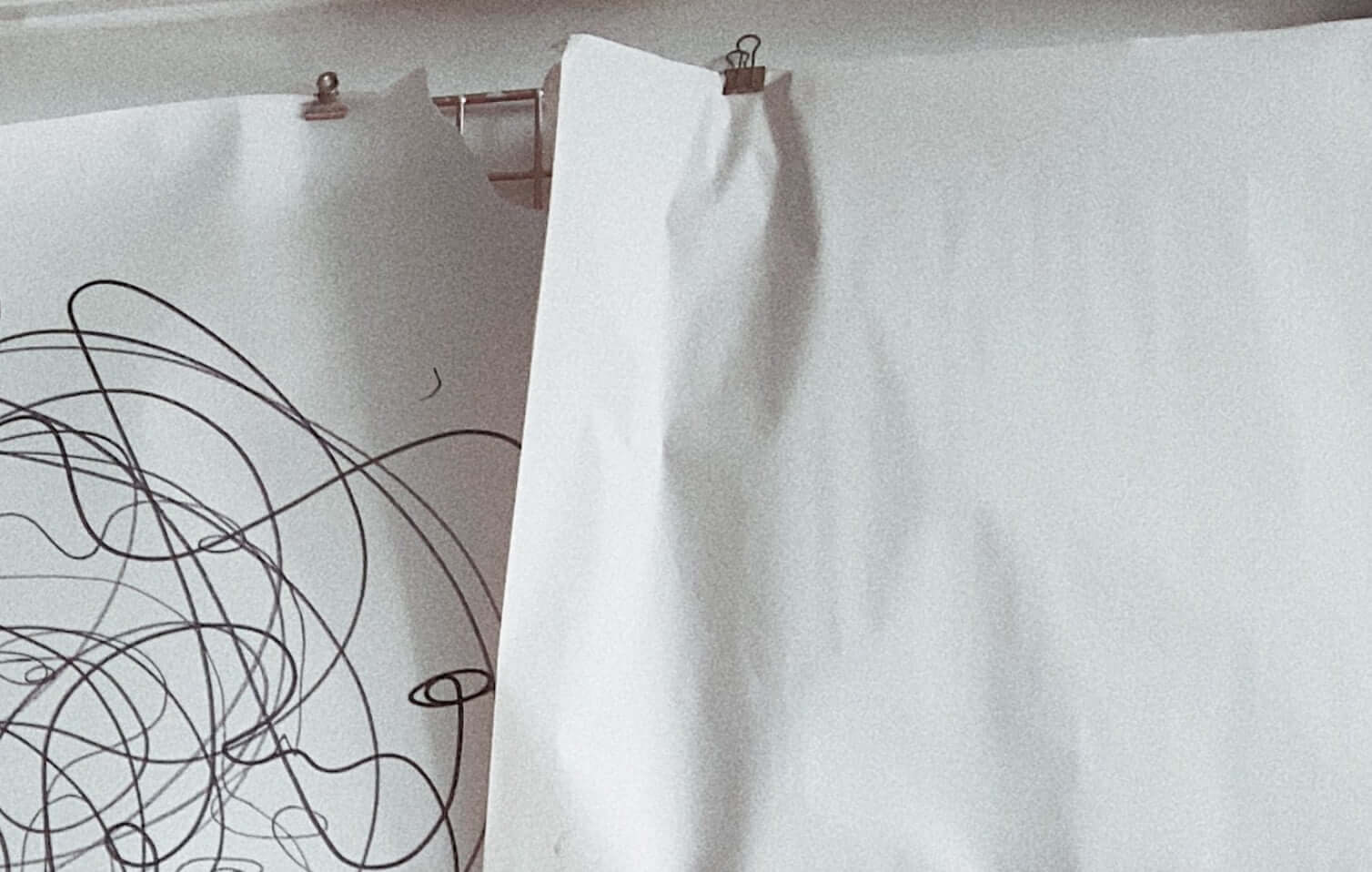 Multiple line drawings are clipped to a metal grid