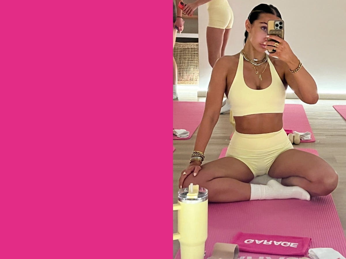Girl poses for a selfie in a light yellow halter top and matching booty shorts.