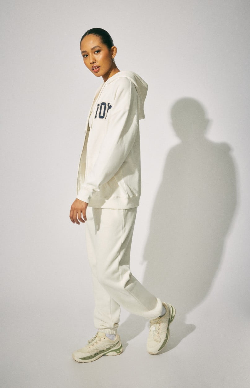 Model wears a white New York hoodie with white sweatpants.