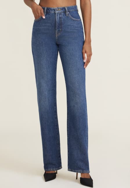 Model is wearing dark blue straight leg jeans.