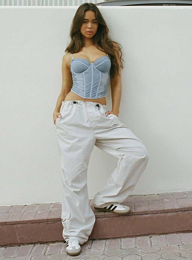 Model is wearing bustier and parachute pants.
