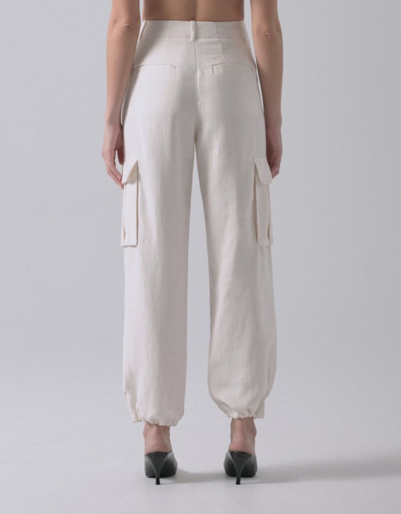 A model wears white cargo parachute pants. - back view.