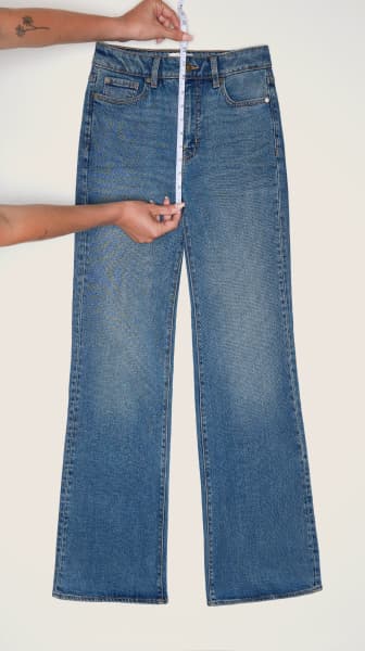 Place the measuring tape from the top of the waistband to the bottom of the crotch seam on a pair of jeans.