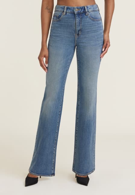 Model is wearing medium blue bootcut leg jeans.
