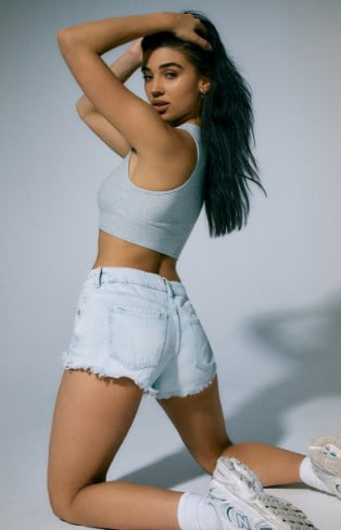 Model is wearing a black mini dress with puff sleeves and cut-out detailing.