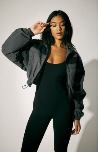 Model is wearing a cropped jacket and a black jumpsuit.