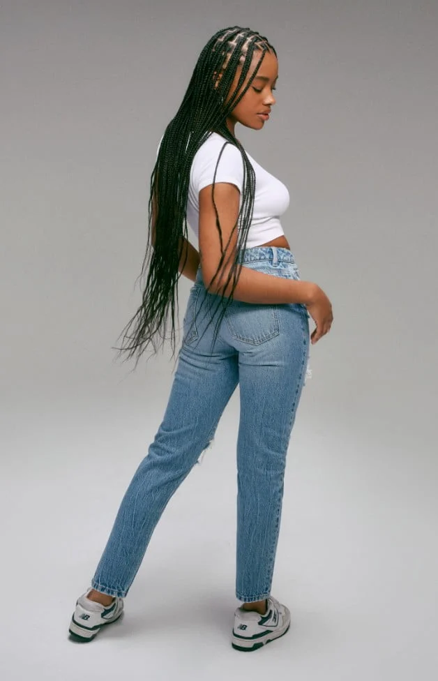Model is wearing a white top and mom jeans
