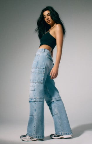 Model is wearing a black crop tank and cargo denim.